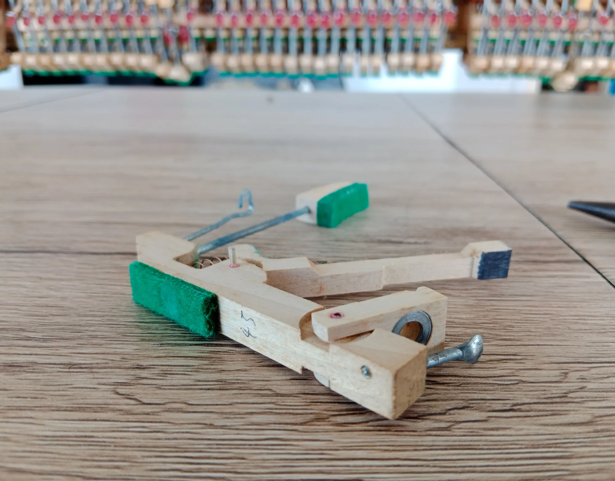 A single piano action part on a workbench, removed for repair